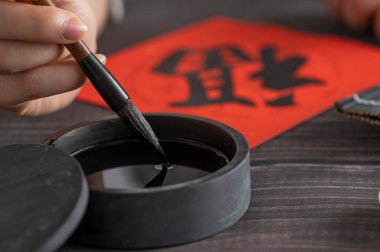 Kırmızı kağıtta geleneksel Çin kaligrafisi.