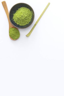 Beyaz arka planda kaşığı olan kibrit yeşil çay tozu