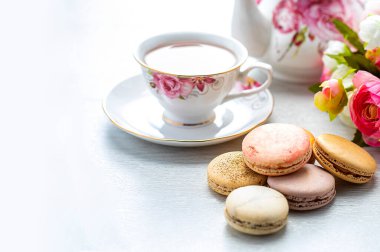 Beyaz arka planda badem kurabiyesi olan bir fincan çay.