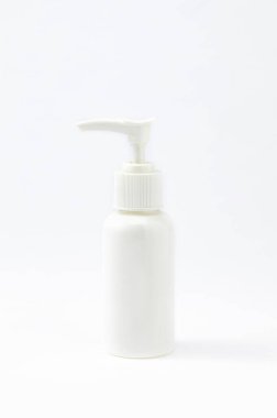 Beyaz plastik şişe, arka planda sabun makinesi var..