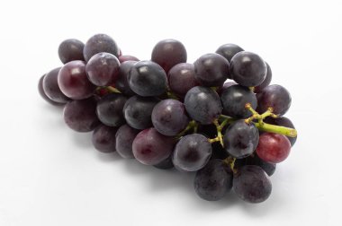 Beyaz arka planda yeşil yapraklı kırmızı üzümler.