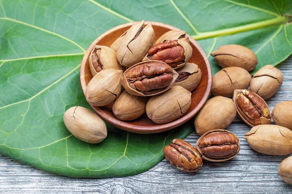 pile of pecan nuts on wooden background