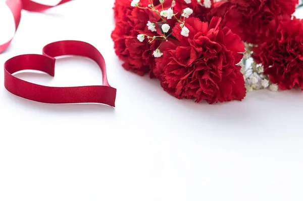Cravos Vermelhos Bonitos Fita Vermelha Forma Coração Fundo Cartão Saudação — Fotografia de Stock