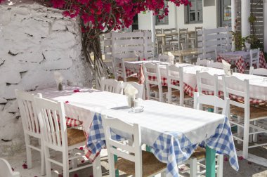beautiful white chairs and tables with flowers on the street
