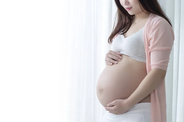 漂亮的孕妇 腹部白皙 背景浅 — 图库照片