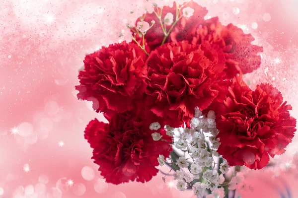 ピンクの背景に赤いカーネーションの花束 — ストック写真