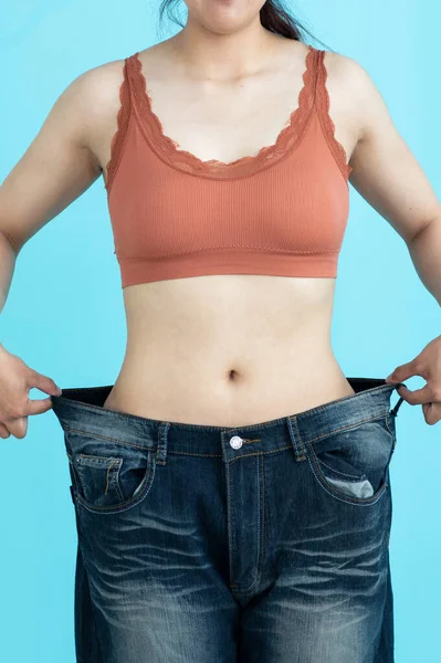 Mujer Mostrando Progreso Pérdida Peso Mostrando Sus Viejos Pantalones Vaqueros — Foto de Stock