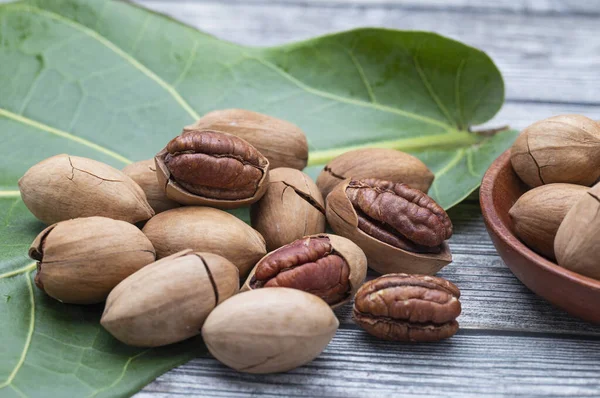 pile of pecan nuts on wooden background