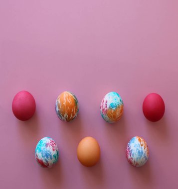 Pembe arka planda çocuklar tarafından elle boyanmış renkli Paskalya yumurtaları. Mutlu Paskalyalar! Metnin için boşluk kopyala