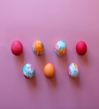 Pembe arka planda çocuklar tarafından elle boyanmış renkli Paskalya yumurtaları. Mutlu Paskalyalar! Metnin için boşluk kopyala