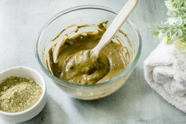 Henna kuru pudra, kına rehidratlı cam kase, mermer bir paspasın üzerinde beyaz terry havlu. Organik çevre dostu boyalardan ev yapımı saç boyası.