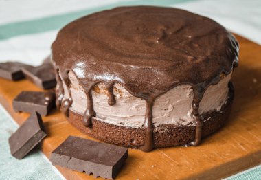 Taze bir ev yapımı kek ahşap bir tahtanın üzerinde. İki sünger keki ve aralarında çikolata ganache ve rendelenmiş acı çikolatayla kaplı bir krema tabakası. Evde kek pişirme süreci. Adım adım tarifli fotoğraf serileri