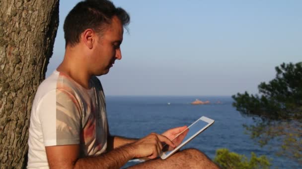 Browsing Tablet Next to the Sea — Stock Video