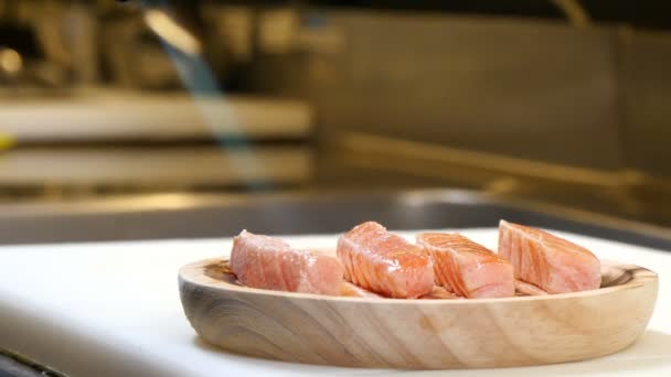 Sushi chef-kok koken zalm met een zaklamp — Stockvideo