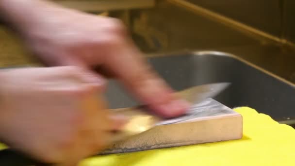 Sushi 01 Sushi-Chef schärft sein Messer mit einem rosa Stein — Stockvideo