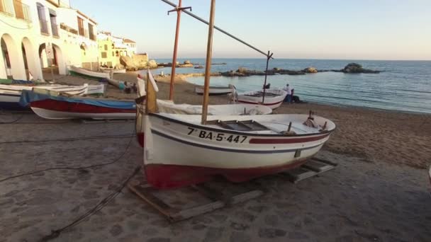 КАЛЕЛЬЯ-ДЕ-ПАЛАФРУГЕЛЬ, ЖИРОНА, КАТАЛОНИЯ. LES VOLTES 2015. Классические ретро деревянные рыболовные лодки, лежащие на песке осенью. Жирона, Испания на Ноябрь 15, 2015 — стоковое видео
