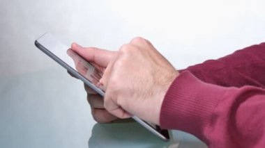 Genç yetişkin adam tablet uygulamaları tarama