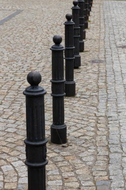 Şehrin kaldırımlarında siyah sütunlar..