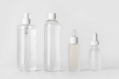 Makyaj seti. Micellar su, toner, yüz serumu ve hyaluronik asit. Açık gri bir arkaplanda.
