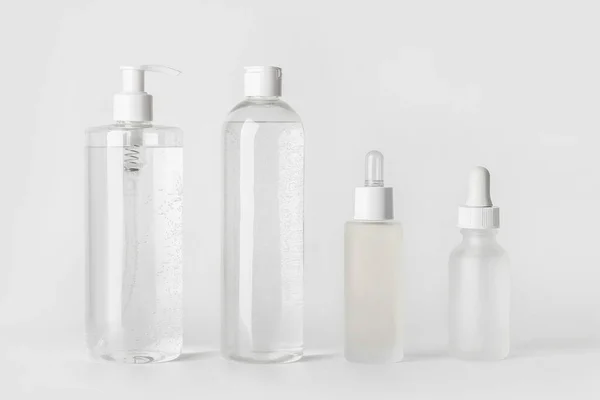 Makyaj seti. Micellar su, toner, yüz serumu ve hyaluronik asit. Açık gri bir arkaplanda.