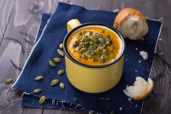 Tasse Kürbissuppe mit Kürbiskernen, Olivenöl und Thymian — Stockfoto