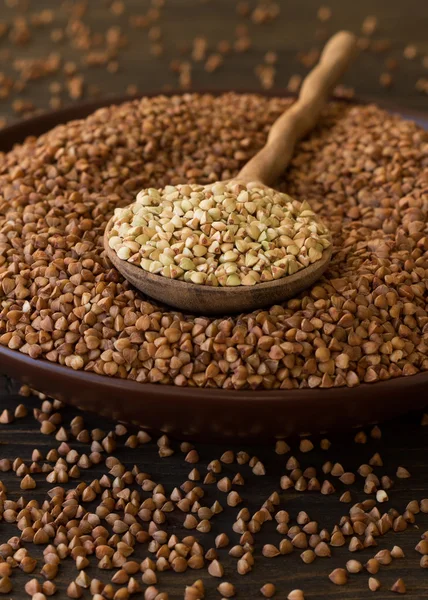 Green and brown buckwheat in ceramic bowl — Stockfoto