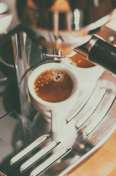 Fresh coffee prepared in the coffee machine. Espresso in small white cups.