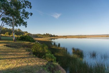 Arjantin 'de gün doğumunda sudaki yansımalarla birlikte arka planda dağ sıraları olan kristal berrak alan lagünü.