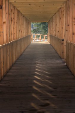 Buzul nehrinin karşısındaki ahşap yapı. Katı meşeden yapılmış modern bir köprü. Doğal mimari orman kütüklerini engelliyor.