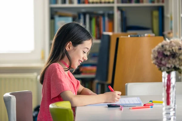 Home schooling because of the global virus epidemic. A young girl doing her homework at home during quarantine.