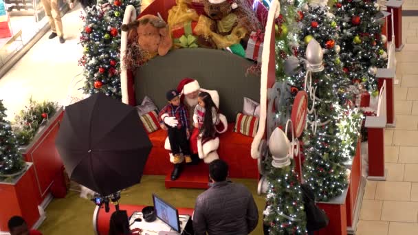 4K karácsonyi Mikulás képeket készít gyerekekkel családi emlékek, bevásárló központ ünnepi szezonban.