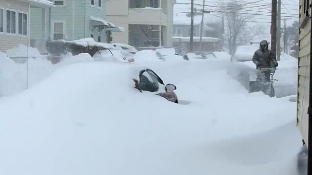 男は雪の送風機が付いている道を清掃します。 — ストック動画