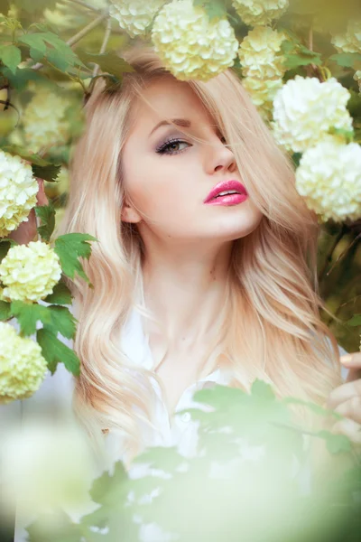 Schöne blonde Frau in Frühlingsblumen — Stockfoto