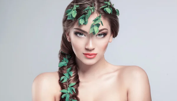 Schönes Mädchen mit frischen grünen Blättern im Haar. Schönheitsmodell — Stockfoto