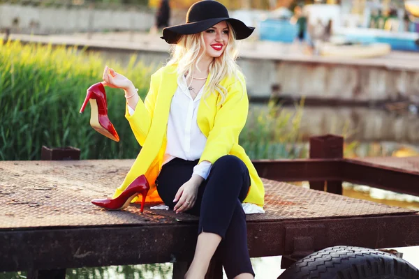 Yaz tatil kavramı. Bri üzerinde oturan güzel genç kadın