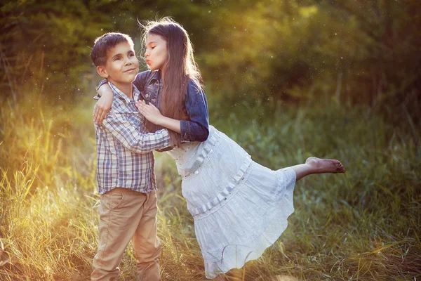 Mooi meisje kussen van een jongen in het park — Stockfoto