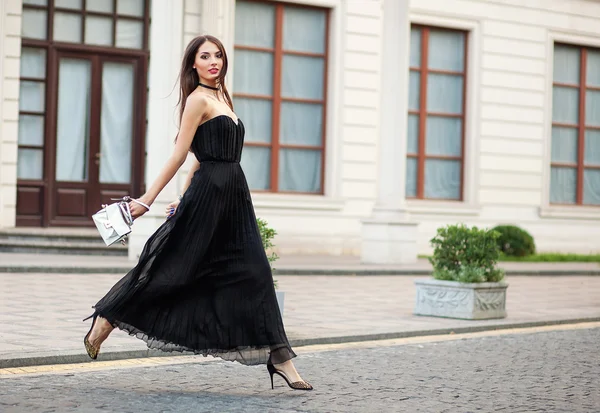 Eautiful jeune femme à la mode en robe longue courir avec sac . — Photo