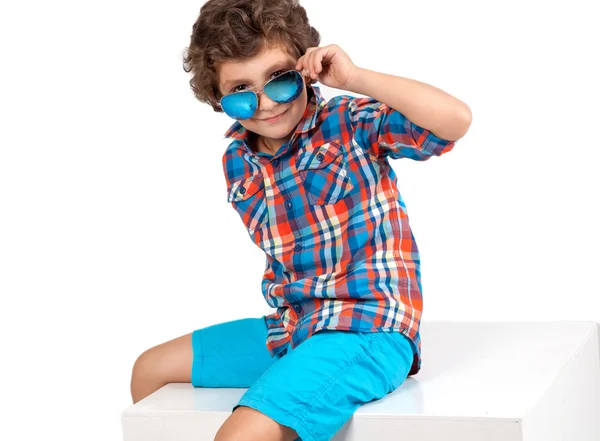 Lindo y divertido niño en camisa a cuadros y pantalones cortos azules —  Fotos de Stock