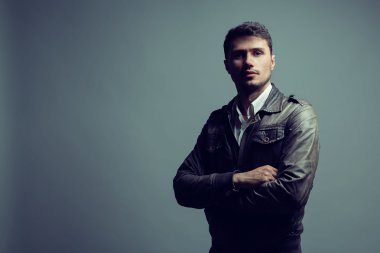 Yakışıklı tarzı. Deri ceketli neşeli akıllı bir genç adam.