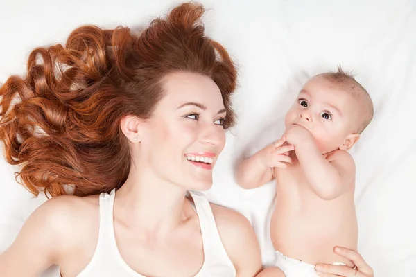 Lycklig familj. Vackra unga röda haired mamma på vit och hennes — Stockfoto