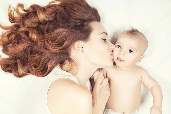 Šťastné rodiny koncept. Krásné mladé červené vlasy matka líbání — Stock fotografie