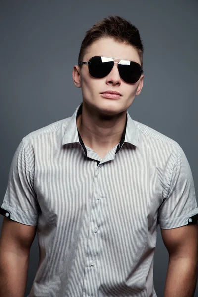 Portrait rapproché d'un jeune homme décontracté avec des lunettes de soleil à la — Photo