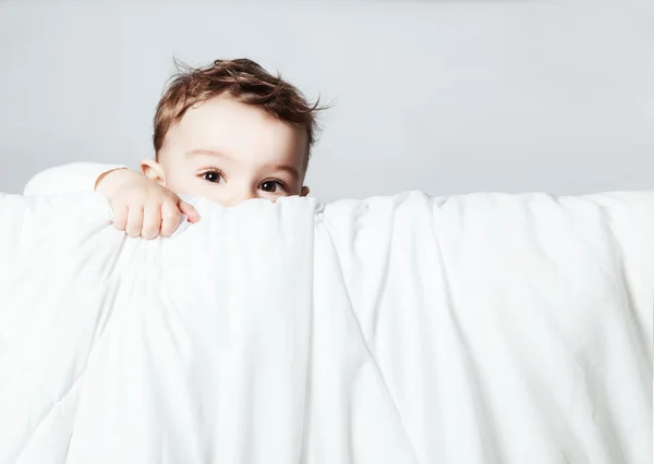 Leuke en grappige baby is op zoek en klimmen op deken over whit — Stockfoto