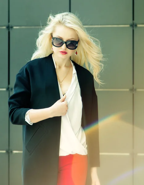 Belle femme d'affaires avec des lunettes de soleil tendance sur le mur noir . — Photo