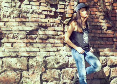Trendy Hipster kız tuğla duvarın üzerinden. Tonda ve filtre uygulanmış fotoğraf. M