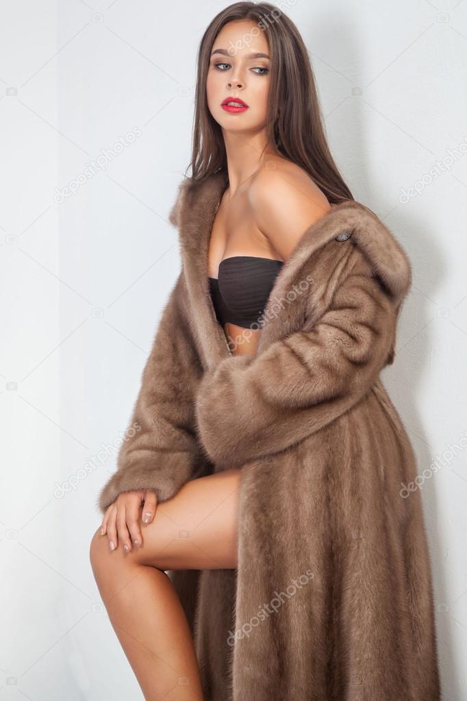 Luxury beautiful woman in fur mink coat with vest looking at cam