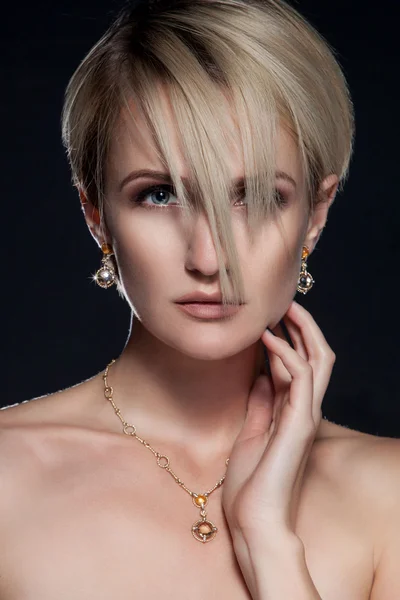 Beautiful young woman with elegant stylish haircut and earrings. — Stock Photo, Image