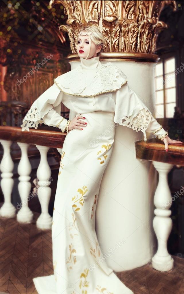 Fashion portrait of beautiful woman in long white dress in an ol