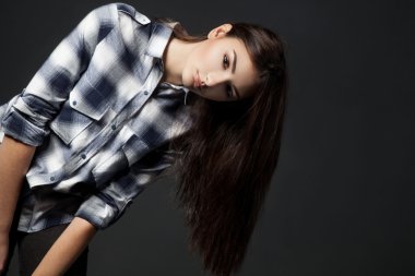 Kameraya gri arka plan üzerinde arayan genç güzel kadın.