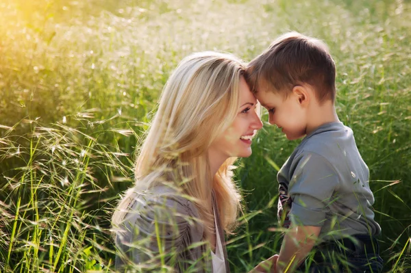 Happy mother and her child having fun outdoor under sunset. — Stock Photo, Image